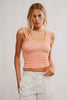 Woman wearing a peach-colored tank top against a plain background