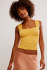 Woman wearing a yellow textured top and pink skirt against a plain background